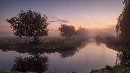 Serene Morning Mist Over Tranquil River Scene wallpaper