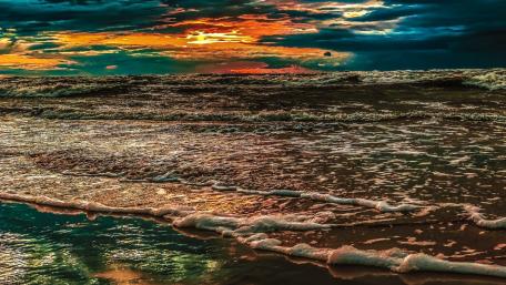 Serene Clouds Embracing Sunset Waves wallpaper