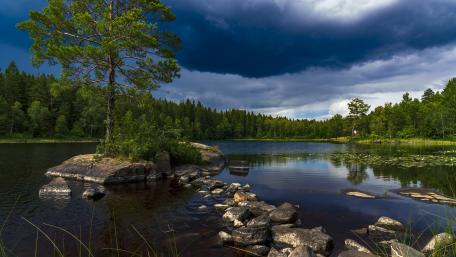 Serene Islet Amidst Wild Clouds wallpaper