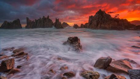 Fiery Sunset Over Rocky Coastline wallpaper