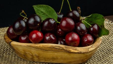 Fresh and Juicy Cherries in a Wooden Bowl wallpaper
