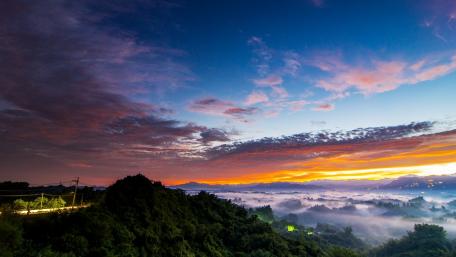 Sunrise Over Misty Mountains Amidst Colorful Skies wallpaper