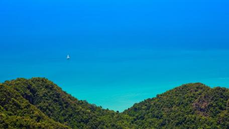 Tranquil Ocean View Over Lush Green Hills wallpaper