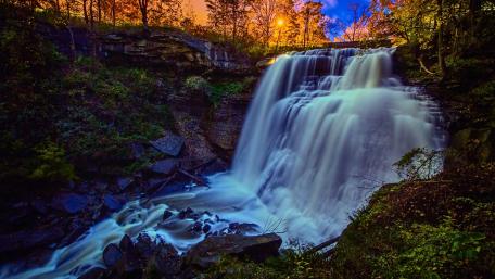 Serene Cascade Amidst Nature's Embrace wallpaper