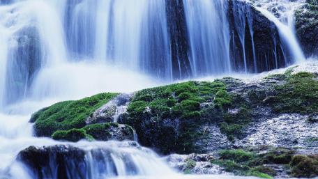 Serene Waterfall Cascading Over Mossy Rocks wallpaper