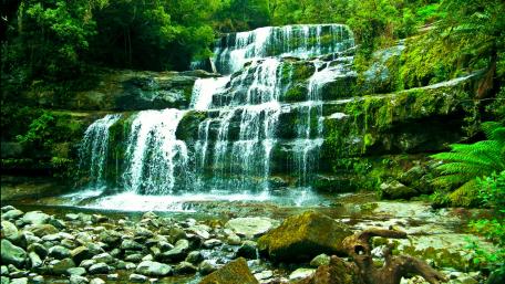 Serene Waterfall Embraced by Lush Greenery wallpaper
