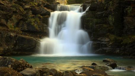 Serene Cascade Flowing Through Nature's Embrace wallpaper