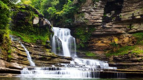 Tranquil Waterfall Amidst Lush Greenery wallpaper