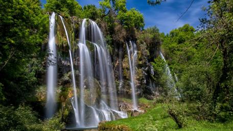 Serene Waterfall Amidst Lush Greenery wallpaper