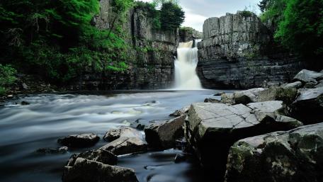 Tranquil Waterfall Amidst Lush Greenery wallpaper