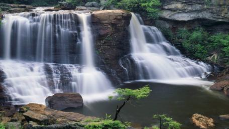 Majestic Waterfall Amidst Lush Greenery wallpaper