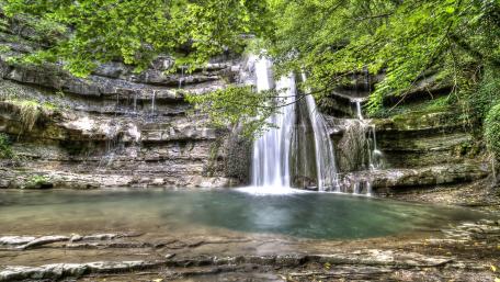 Serene Waterfall in a Lush Forest Scene wallpaper