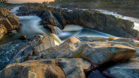 Majestic River Flowing Through Rocky Landscape wallpaper