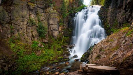 Majestic Waterfall in a Lush Forest Setting wallpaper