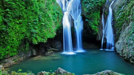 Serene Waterfall Surrounded by Lush Greenery wallpaper