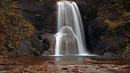 Majestic Waterfall in Serene Landscape wallpaper