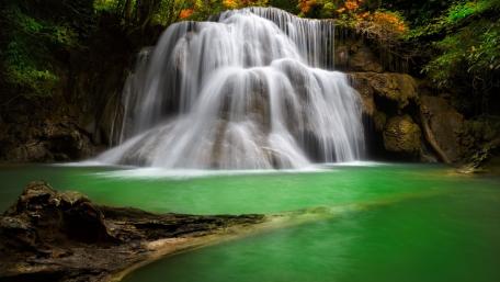 Serenity of a Cascading Waterfall Amidst Lush Greenery wallpaper