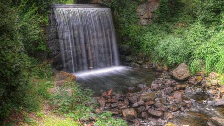 Serene Waterfall Amidst Lush Greenery wallpaper