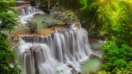Serene Waterfall Retreat Amidst Lush Greenery wallpaper