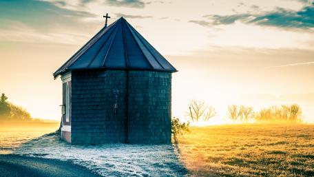 Serene Chapel Amidst Golden Dawn Light wallpaper