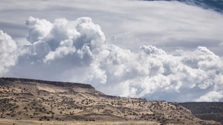 Majestic Clouds Over Serene Landscape wallpaper