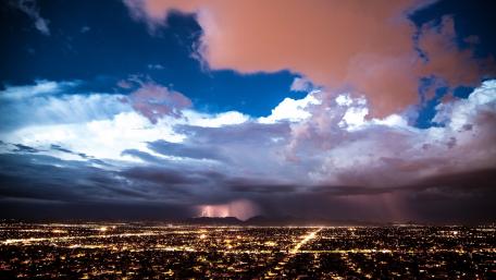 Stormy Cityscape Illuminated by Lightning Flashes wallpaper