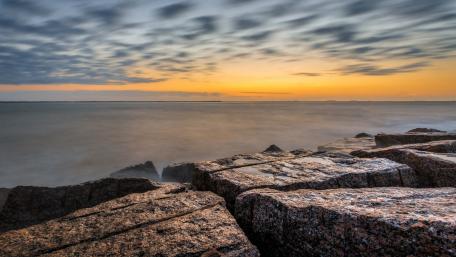 Serene Sunset Over Rocky Shoreline wallpaper