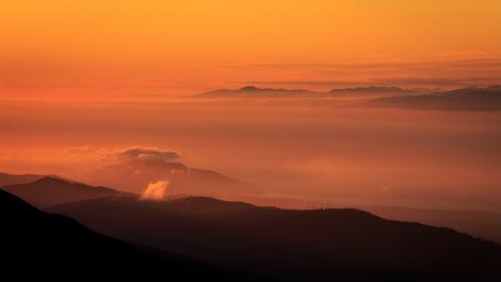 Majestic Mountains at Sunset Glistening in Orange Glow wallpaper