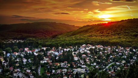 Serene Village at Sunset Amidst Rolling Hills wallpaper