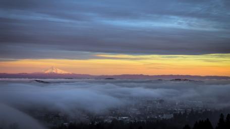 Sunrise Over Misty Mountains and Cityscape wallpaper