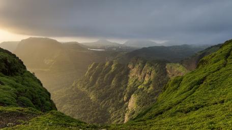 Majestic Green Valley Among Mountain Peaks wallpaper