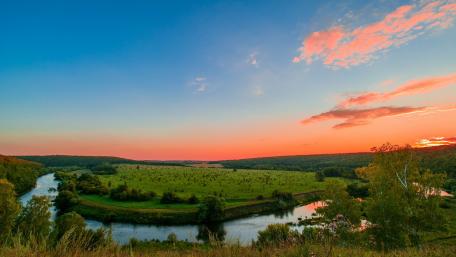 Serene River at Dusk in Lush Green Landscape wallpaper