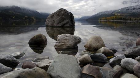 Serene Lake Reflection with Boulders wallpaper