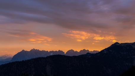 Majestic Mountain Sunset Over Rolling Hills wallpaper