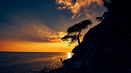 Tranquil Sunset Over Hillside Shoreline wallpaper