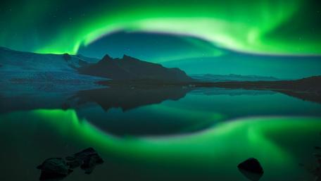 Northern Lights Dance Over Serene Lake Reflection wallpaper