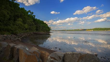 Scenic Riverbank Under Blue Sky wallpaper