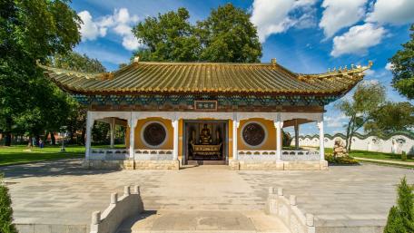 Serene Temple Amidst Lush Greenery and Blue Skies wallpaper