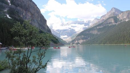 Serene Lake Surrounded by Majestic Mountains and Lush Forests wallpaper