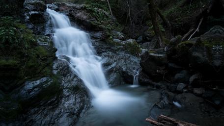 Serene Waterfall in Lush Forest Setting wallpaper