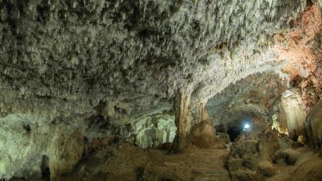 Mysterious Cave Interior with Stalactites and Stalagmites wallpaper