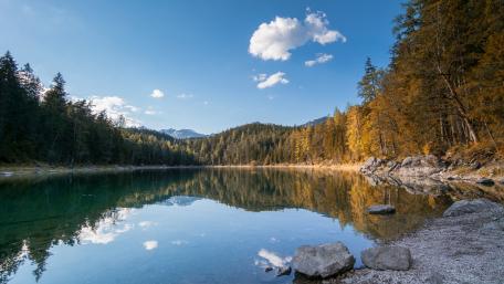 Serene Lake Reflection Under Fluffy Clouds wallpaper