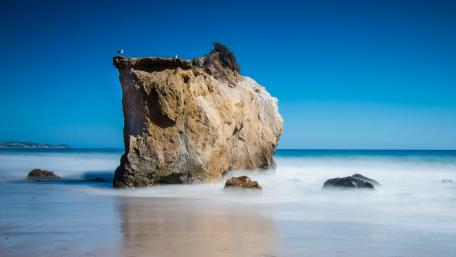Majestic Sea Stack Against Blue Horizon wallpaper