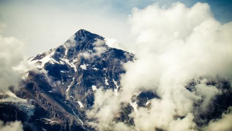 Majestic Mountain Peak Amidst Clouds wallpaper