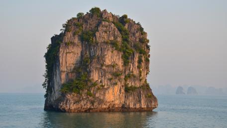 Majestic Sea Stack Rising from Tranquil Waters wallpaper