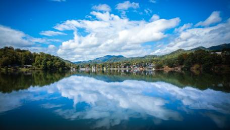Tranquil Lake Reflection Under a Bright Sky wallpaper
