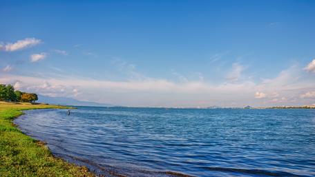 Serene Waterfront Landscape with Clear Blue Skies wallpaper