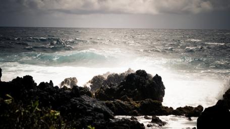 Serene Ocean Waves Amidst Rugged Rocks wallpaper