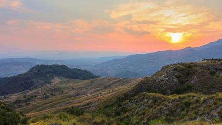 Serene Sunset Over Rolling Hills and Valleys wallpaper