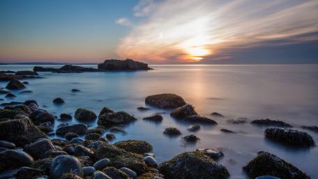 Tranquil Sunset Over Rocky Shoreline wallpaper